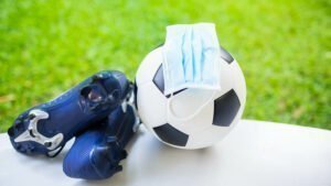 Soccer ball with cleats and mask near green field 1